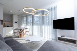 a living room with a couch and a chandelier at HEVENIA POGORZELICA - APARTAMENT 2 in Pogorzelica