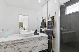 a bathroom with a sink and a mirror at Panoramic Ocean Views in the Heart of Torquay in Torquay