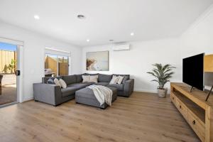 een woonkamer met een bank en een flatscreen-tv bij Seaspray Ocean View Retreat in Torquay