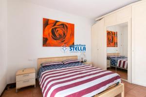 una camera da letto con un letto e un dipinto sul muro di Foresteria Golf a Jesolo