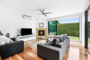 a living room with a couch and a tv at Luxury Torquay Townhouse 150m to Beach in Torquay