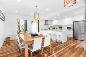 a kitchen and dining room with a wooden table and chairs at Luxury Torquay Townhouse 150m to Beach in Torquay