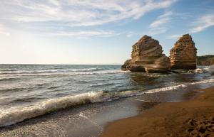 ein Strand mit zwei großen Felsen im Ozean in der Unterkunft Hotel Celeste in Procida