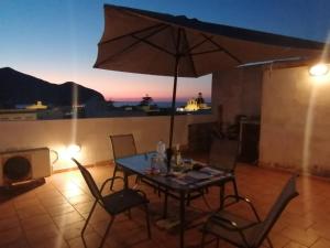 a table with chairs and an umbrella on a patio at Subito in Centro in Favignana