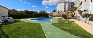 un patio trasero con piscina y césped en 5 Campoamor Golf, en Campoamor