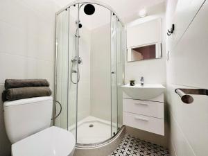 een badkamer met een douche, een toilet en een wastafel bij Studio przy Placu Jasia Rybaka in Sopot
