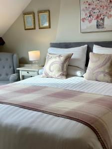 a bedroom with a large bed with pillows at Broom House at Egton Bridge in Egton