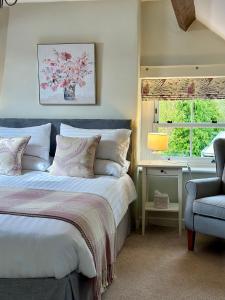 a bedroom with a bed and a chair and a window at Broom House at Egton Bridge in Egton