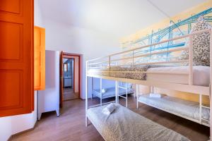 a room with two bunk beds and a hallway at The Macarena Beach Hostel in Lagos