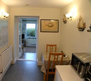 eine Küche und ein Esszimmer mit einem Tisch und Stühlen in der Unterkunft Seaview at Merton Hall Dinas Cross in Dinas