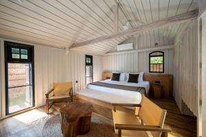 a bedroom with a bed and a chair in it at Ocean front cabin in Madiha in Kamburugamuwa