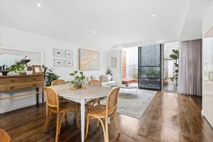 a dining room and living room with a table and chairs at Whitewash Beachfront Apartment on The Esplanade in Torquay
