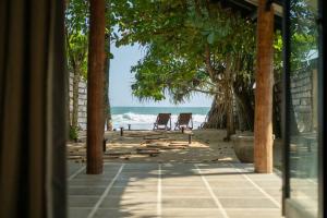 a view of a beach with two chairs and the ocean at Ocean front cabin in Madiha in Kamburugamuwa