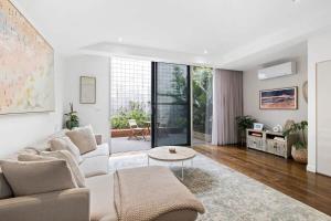 a living room with a couch and a table at Whitewash Beachfront Apartment on The Esplanade in Torquay