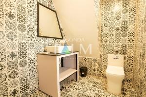 a bathroom with a toilet and a mirror at Agonda Palm Beach Resort in Agonda