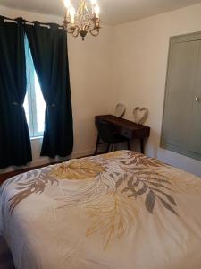 ein Schlafzimmer mit einem Bett, einem Kronleuchter und einem Fenster in der Unterkunft Appartement centre ville in Vimoutiers