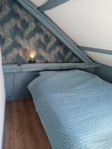 een stapelbed in een kamer met een blauw laken bij Appartement centre ville in Vimoutiers