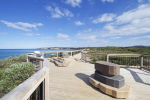 a wooden deck with a view of the ocean at Whitewash Beachfront Apartment on The Esplanade in Torquay