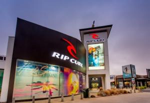 a rip summit store with signs on the side of it at Whitewash Beachfront Apartment on The Esplanade in Torquay