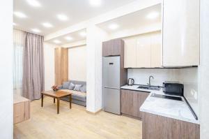 a kitchen with a sink and a refrigerator and a table at 15. Double room apartaments with fresh style in Yerevan