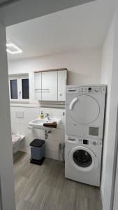 a bathroom with a washing machine and a sink at Gemütlich, ländlich, stadtnah in Stutensee