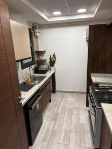 a kitchen with a sink and a stove at Aura Apartments CFC in Cairo