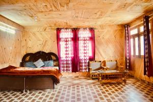 - une chambre avec un lit dans une pièce dotée de murs en bois dans l'établissement Pahadi Bliss Hostel ,Tosh, à Tosh