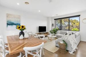 a living room with a table and a couch at Sands Coastal Villa Close to Pool, Beach and Golf in Torquay
