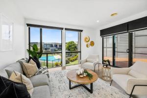 a living room with a couch and a table at Sands Coastal Villa Close to Pool, Beach and Golf in Torquay