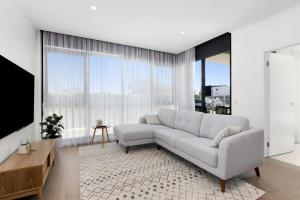 uma sala de estar com um sofá e uma grande janela em Urban Executive Style Meets Relaxed Coastal Vibes em Ocean Grove