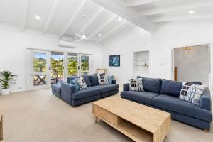 a living room with blue couches and a coffee table at Bellarine Lake House Ocean Grove in Ocean Grove