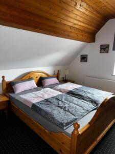 um quarto com uma cama de madeira e um tecto de madeira em FewoVolmetal em Meinerzhagen