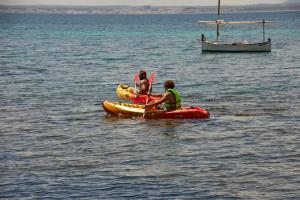 two people on a raft in the water with a boat at Inmood Aucanada 4 Sup in Port d'Alcudia