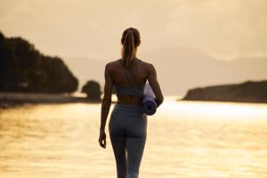 a woman walking on the beach with a camera at Inmood Aucanada 4 Sup in Port d'Alcudia