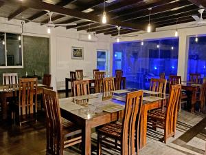 a dining room with a table and wooden chairs at Grand Detagamuwa in Kataragama
