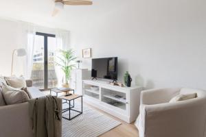 Una sala de estar blanca con un sofá y un televisor. en Apartamento La Nuez by Clabao, en Pamplona 11 fotos más
