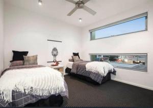 1 Schlafzimmer mit 2 Betten und einem Fenster in der Unterkunft Penthouse apartment with breathtaking sea views in Ocean Grove