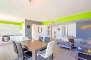 a kitchen and living room with a wooden table and chairs at Les Aloes - Appt climatisé vue mer et montagne in Calvi