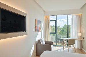 a living room with a tv and a table and chairs at INNSiDE by Meliá Tenerife Santa Cruz in Santa Cruz de Tenerife