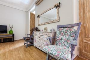 a room with a chair and a dresser and a mirror at Sweet Home at Rustaveli Avenue in Tbilisi City