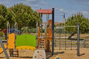 a playground with a slide and a swing at Kampaoh Côte Sauvage in Saint-Clément-des-Baleines