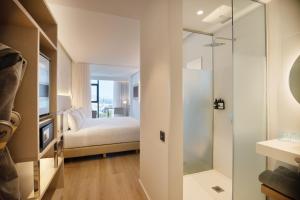 a bathroom with a bed and a glass shower at INNSiDE by Meliá Tenerife Santa Cruz in Santa Cruz de Tenerife