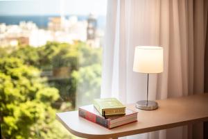 two books and a lamp on a table with a window at INNSiDE by Meliá Tenerife Santa Cruz in Santa Cruz de Tenerife