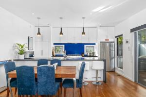 a kitchen with a wooden table and blue chairs at Sunset Days Family Holiday House 200m to Shops in Ocean Grove