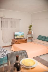 a living room with two beds and a tv at Holiday Gufetto in Pietra Ligure