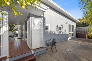 a house with a deck with a table and chairs at Sunset Days Family Holiday House 200m to Shops in Ocean Grove