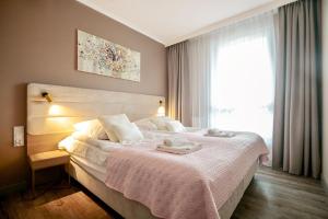 ミエンジズドロイェにあるBelMare by Baltic Homeの窓のある大きな白いベッドのある寝室 +16枚の写真