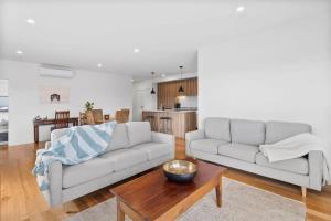 a living room with a couch and a table at Boardwalk on Bright Coastal Apartment in Torquay