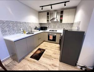 uma cozinha com um frigorífico preto e piso em madeira em Stay with wambui em Nairobi