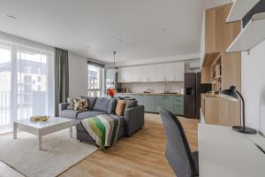 a living room with a couch and a table and a kitchen at Fantasy House, cozzy apartmens, free parking, long stays welcome in Vilnius